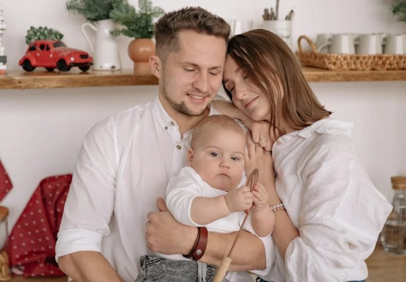 A joyful family of three embracing in a cozy kitchen. Warm and loving atmosphere.